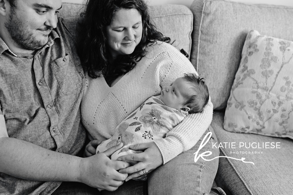In-home newborn photography session in Connecticut with parents holding their baby