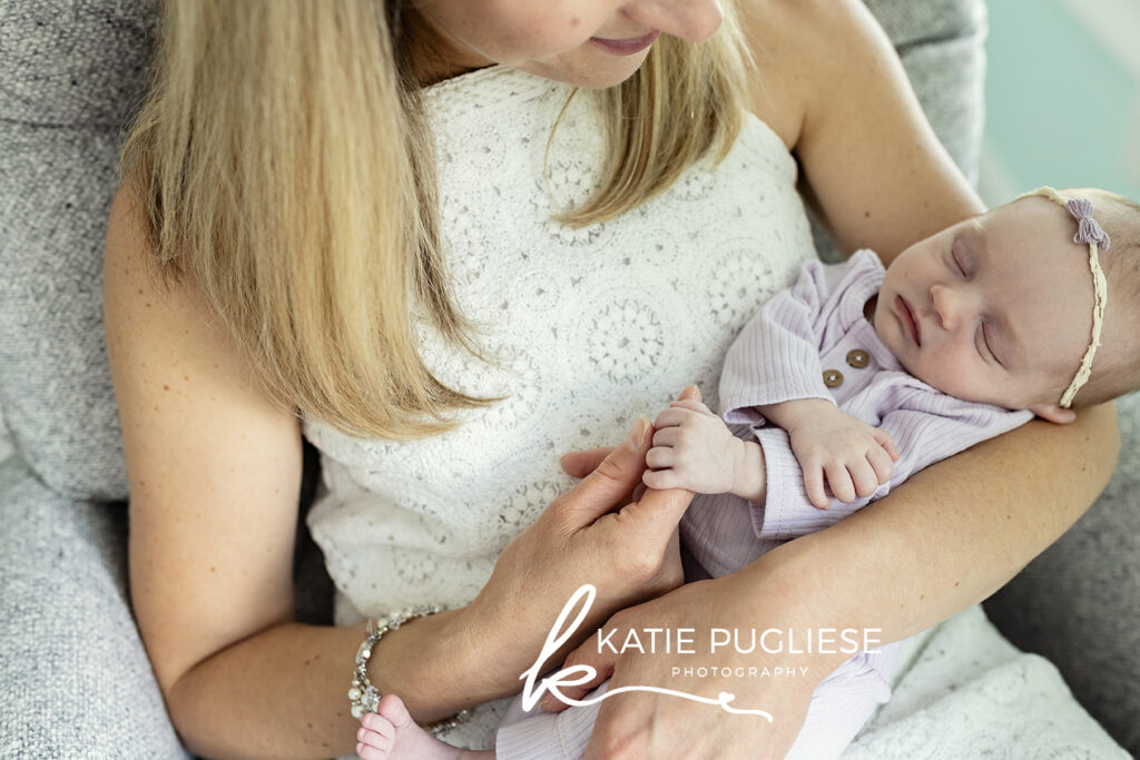 In-home newborn photography session in Connecticut with parents holding their baby