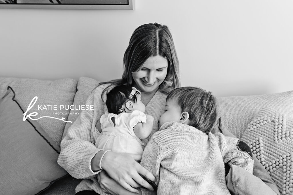 Parents cuddling their newborn during a relaxed in-home photography session in Connecticut